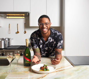 Chef Kwame Onwuachi with a bottle of Mumm Champagne