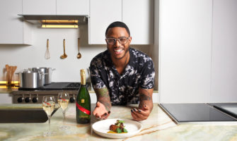 Chef Kwame Onwuachi with a bottle of Mumm Champagne